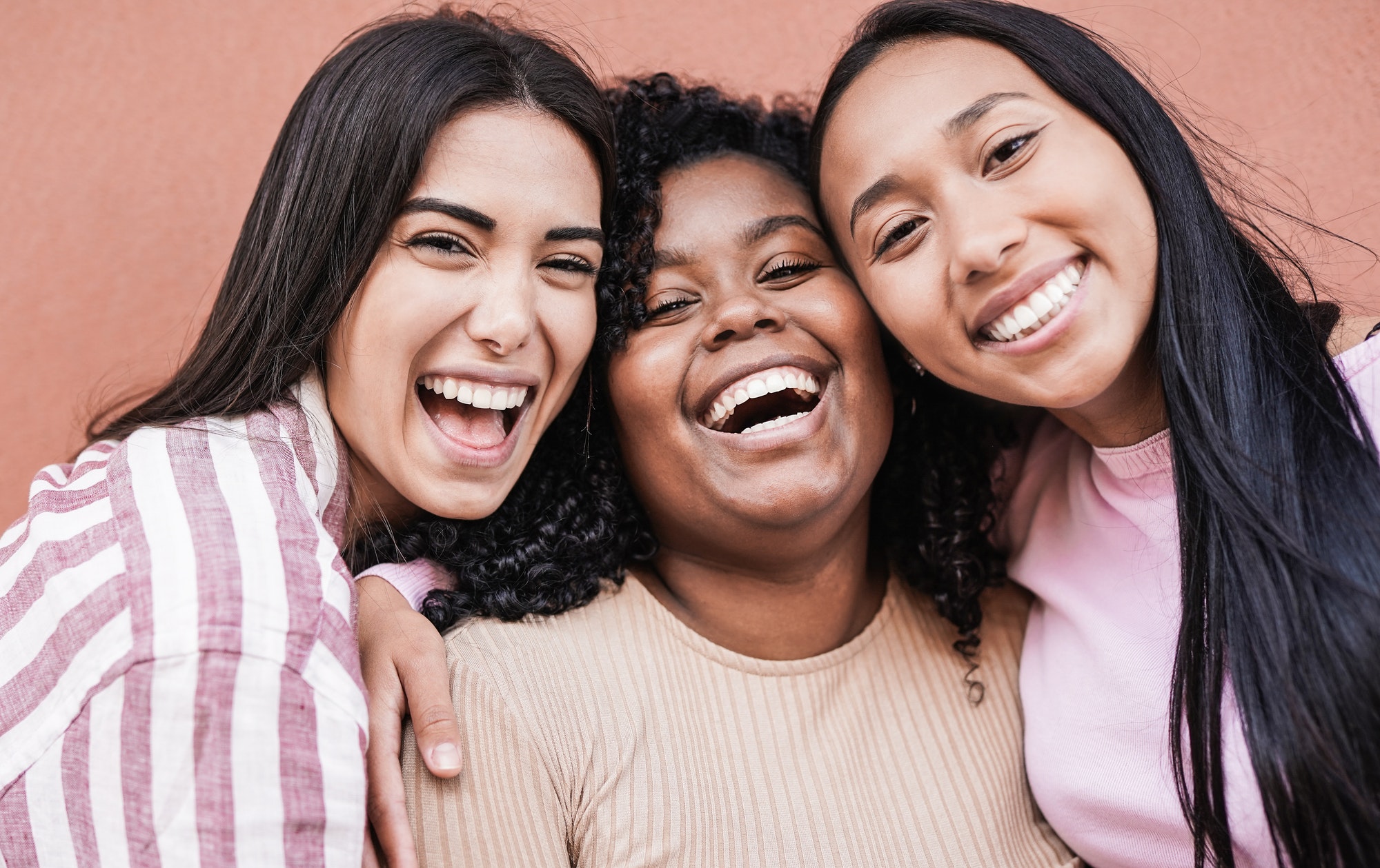 Happy latin women laughing and looking in camera